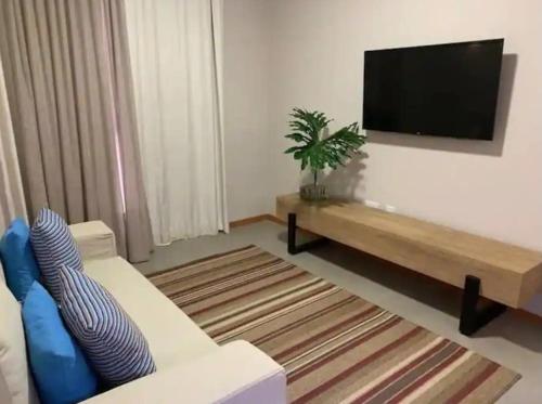 a living room with a couch and a flat screen tv at Quinta Santa Bárbara Eco Resort in Pirenópolis