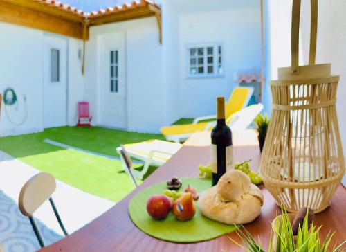 un piatto di cibo e una bottiglia di vino su un tavolo di Sado Guest House ad Alcácer do Sal
