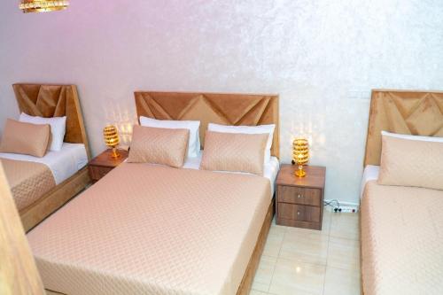 a room with two beds and two lamps on tables at Luxury Apartments Tangier in Tangier