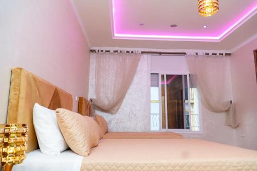 a bedroom with a bed and a purple lighting at Luxury Apartments Tangier in Tangier