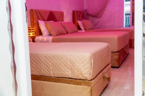 two beds in a room with pink walls at Luxury Apartments Tangier in Tangier