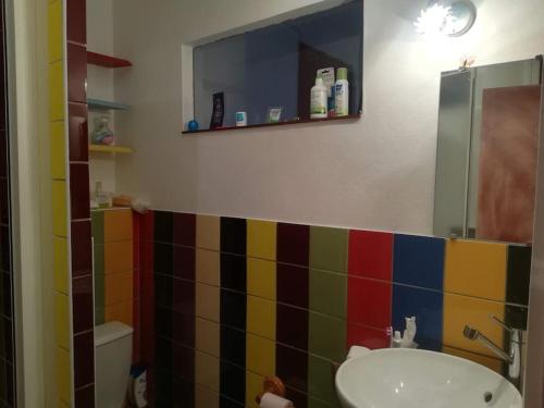 La salle de bains est pourvue d'un lavabo et d'un mur carrelé coloré. dans l'établissement Apartment near Disney, 25 min from Paris, à Thorigny-sur-Marne