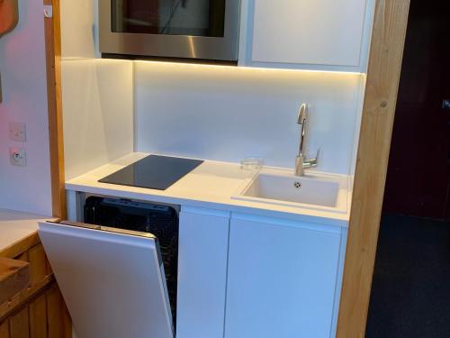 une cuisine avec un évier et un micro-ondes dans l'établissement Studio cosy · Ski aux pieds · Balcon · 4 pers - FR-1-346-459, à Arc 1800
