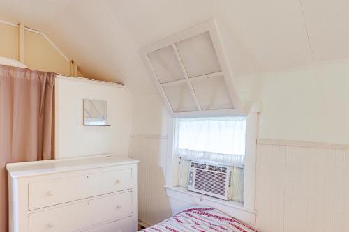 a bedroom with a window and a air conditioner at Walk to Lake Historic Lakeside Marblehead Cottage in Lakeside