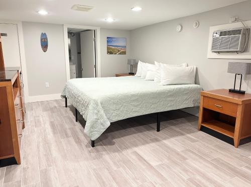 a bedroom with a bed and a night stand and a table at Abellona Inn & Suites in Old Orchard Beach