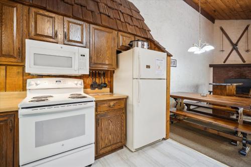 a kitchen with white appliances and wooden cabinets at 4-Bedroom Townhouse with Sauna Snow Flurry in Killington