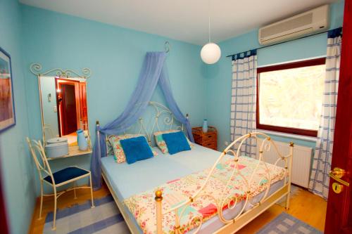 a blue bedroom with a bed and a window at Villa Bugenvilla in Lokva Rogoznica