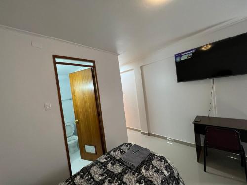 a bedroom with a bed and a desk and a mirror at Hotel Orozco in Antofagasta