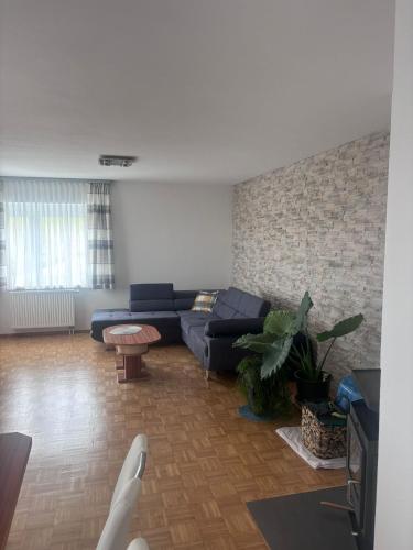 a living room with a blue couch and a brick wall at Romy in Deutschlandsberg