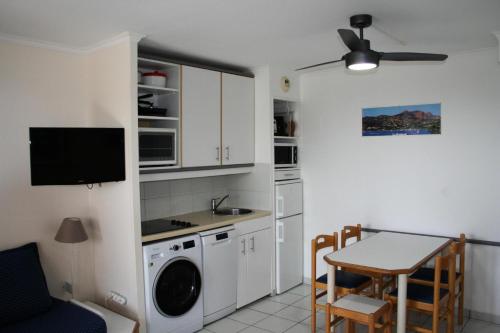 - une cuisine avec une table, un évier et un lave-linge dans l'établissement Résidence le Hameau de Cap Esterel - maeva Home - Appartement 2 Pièces 5 Personnes - Sélection MAE-5802, à Saint-Raphaël