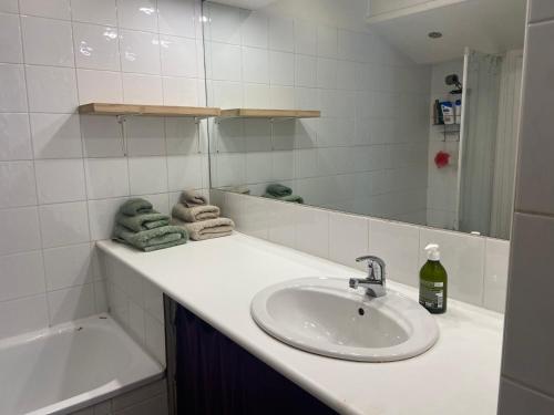 une salle de bain avec un lavabo, une baignoire et un miroir dans l'établissement T2 Marseille 13008, à Marseille