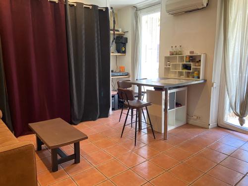 une cuisine avec une table et des chaises dans une pièce dans l'établissement T2 Marseille 13008, à Marseille