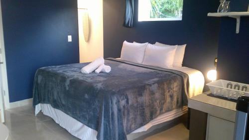 a hotel room with a bed with two towels on it at E&J Boutique Residences in Sosúa