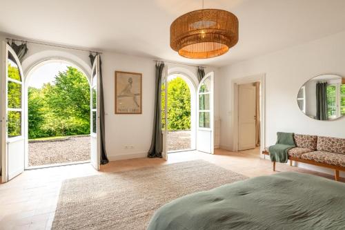 a bedroom with a bed and two arched windows at Domaine la Boissière in Grand Brassac