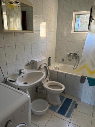 a bathroom with a toilet and a sink and a tub at Apartment Šušanj in Bar
