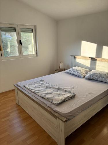 a large bed in a room with two windows at Apartment Šušanj in Bar