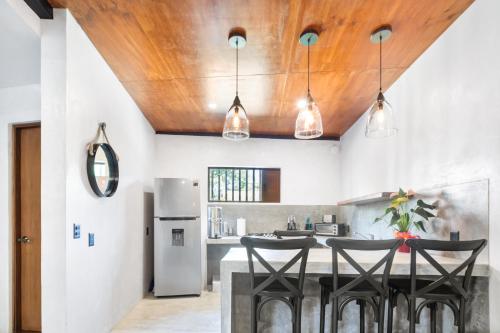 a kitchen with a wooden ceiling and black stools at Welcome to Paradise - Luxurious Studio Oasis "Artemisa" with Pool and Lush Tropical Gardens in Sayulita