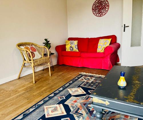 a living room with a red couch and a table at Mountain view 2-bedroom Pyrenees apartment in Saint-Béat