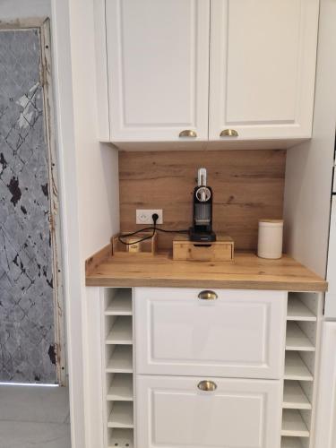 a kitchen with white cabinets and a coffee maker on a counter at VILLA Soleil et Douceur in La Seyne-sur-Mer