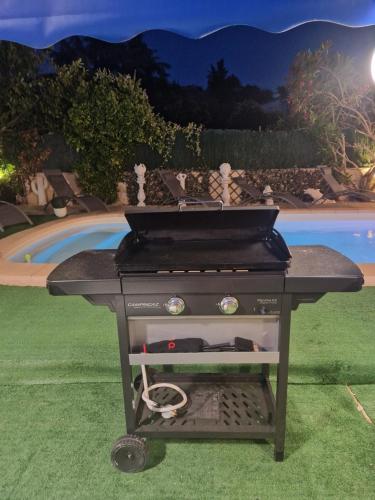 a grill sitting on the grass in a yard at VILLA Soleil et Douceur in La Seyne-sur-Mer