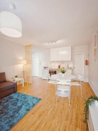 a living room with a white table and a kitchen at Alameda Apartments in Trofa