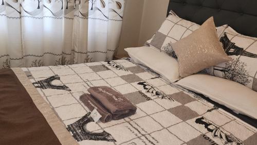 a bed with a blanket and pillows on it at Palm West in Bulawayo