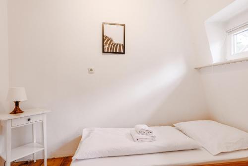 a white room with a bed and a picture on the wall at Am Weissen Turm in Kulmbach