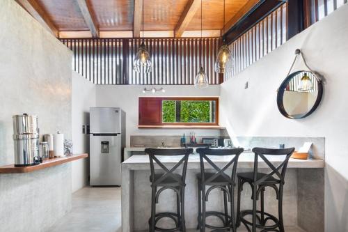 a kitchen with a counter with four stools at Welcome to Paradise - Luxurious 2 Bedroom Oasis with Pool and Lush Tropical Garden in Sayulita