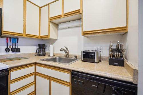a kitchen with a sink and a microwave at 3-Bedroom Condo Ski-In, Shuttle, and Cozy Fireplace Whiffletree I3 in Killington
