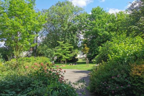 a path in a park with trees and flowers at Stunning Parkview Apartment close to Paris in Cachan