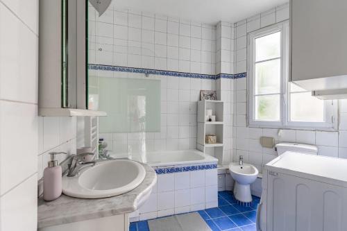 a bathroom with a sink and a tub and a toilet at Stunning Parkview Apartment close to Paris in Cachan