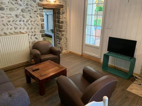 un salon avec un canapé, une table et une télévision dans l'établissement Au chants des Grenouilles, à Préchacq-Josbaig