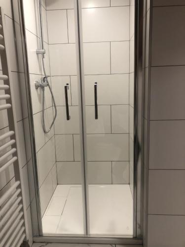 une douche avec une porte vitrée dans une salle de bain dans l'établissement Chalet Leslie, à Morzine