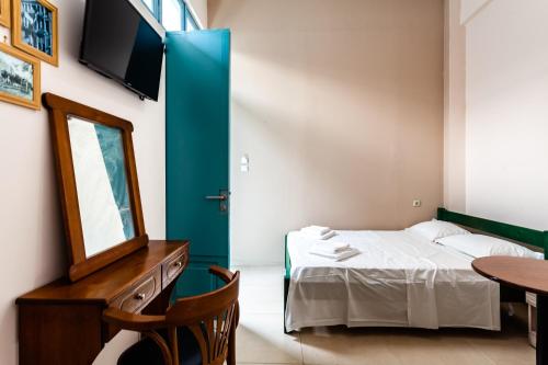 a room with a bed and a mirror and a table at Στούντιο Στη Στοά Βαρβουτσή #3 in Kalamata