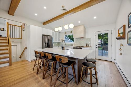 a kitchen with a large island with bar stools at Modern Mid-Century Retreat in West Chester