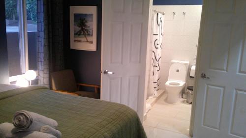 a bedroom with a bed and a bathroom with a toilet at E&J Boutique Residences in Sosúa