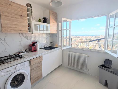 une cuisine avec une machine à laver et une fenêtre dans l'établissement Nice view, à Nice