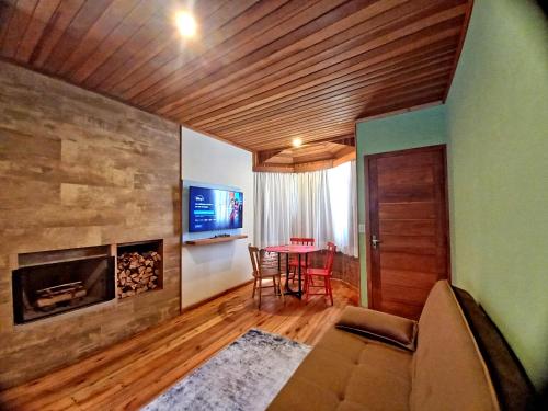 a living room with a fireplace and a table at Pousada Visconde de Mauá in Visconde De Maua