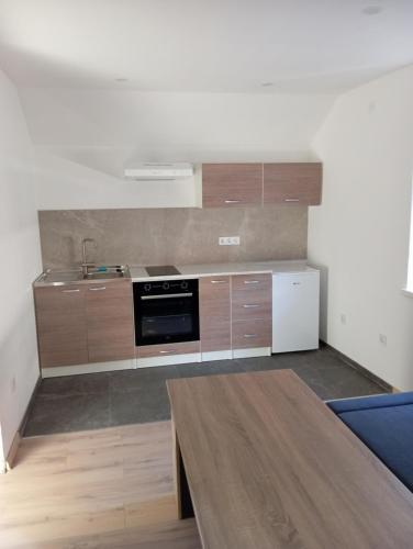 サラエボにあるREAL apartmentの木製のキャビネットとコンロ付きオーブンを備えたキッチン