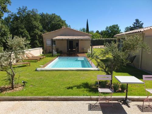 une cour arrière avec une piscine et une maison dans l'établissement La Villa Sable en Provence, à Saint-Saturnin-lès-Apt