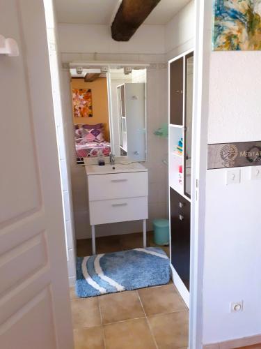 La salle de bains est pourvue d'une coiffeuse, d'un lavabo et d'un miroir. dans l'établissement Gîte ArtMonie, à Raissac-dʼAude