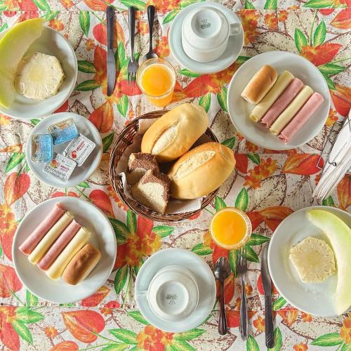 un tavolo ricoperto di piatti di hot dog e pane di Pousada Kybalion a Búzios