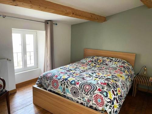 une chambre avec un lit avec une couette colorée dans l'établissement Jolie maison proche du centre ville, à La Rochelle