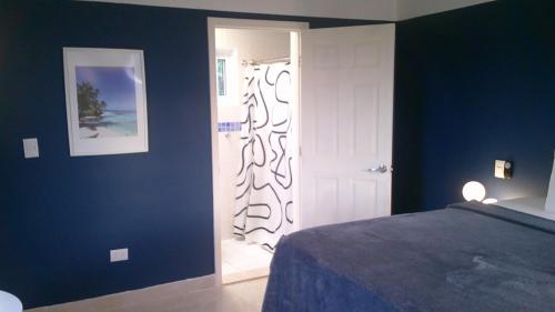 a blue bedroom with a bed and a white door at E&J Boutique Residences in Sosúa