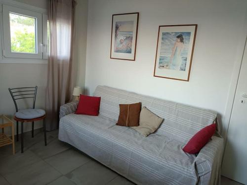 PosidhoníaにあるSantina's houseのリビングルーム(赤い枕とグレーのソファ付)