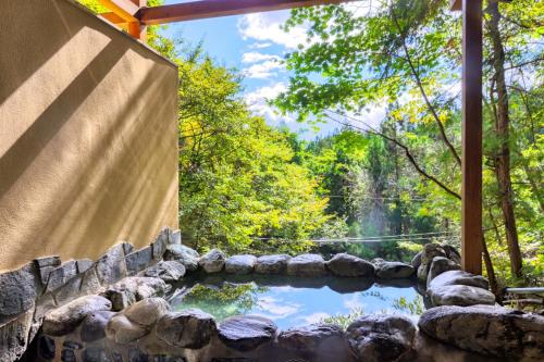 a pool of water in a stone wall with a waterfall at Pension Yumi - Vacation STAY 20865v in Nikko
