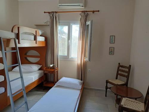 PosidhoníaにあるSantina's houseのベッドルーム1室(二段ベッド1組、テーブル、椅子付)