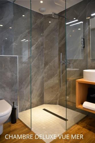 a shower with a glass door in a bathroom at HOTEL SAINT ROCH in Ogliastro