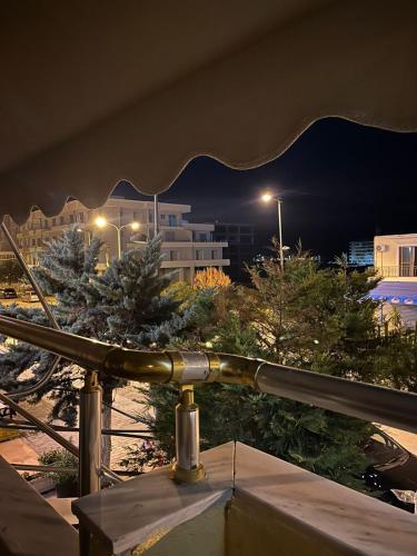 a view of a city at night from a balcony at Nina's Rooms in Orikum
