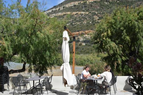 two women sitting at tables under an umbrella at HOTEL SAINT ROCH in Ogliastro